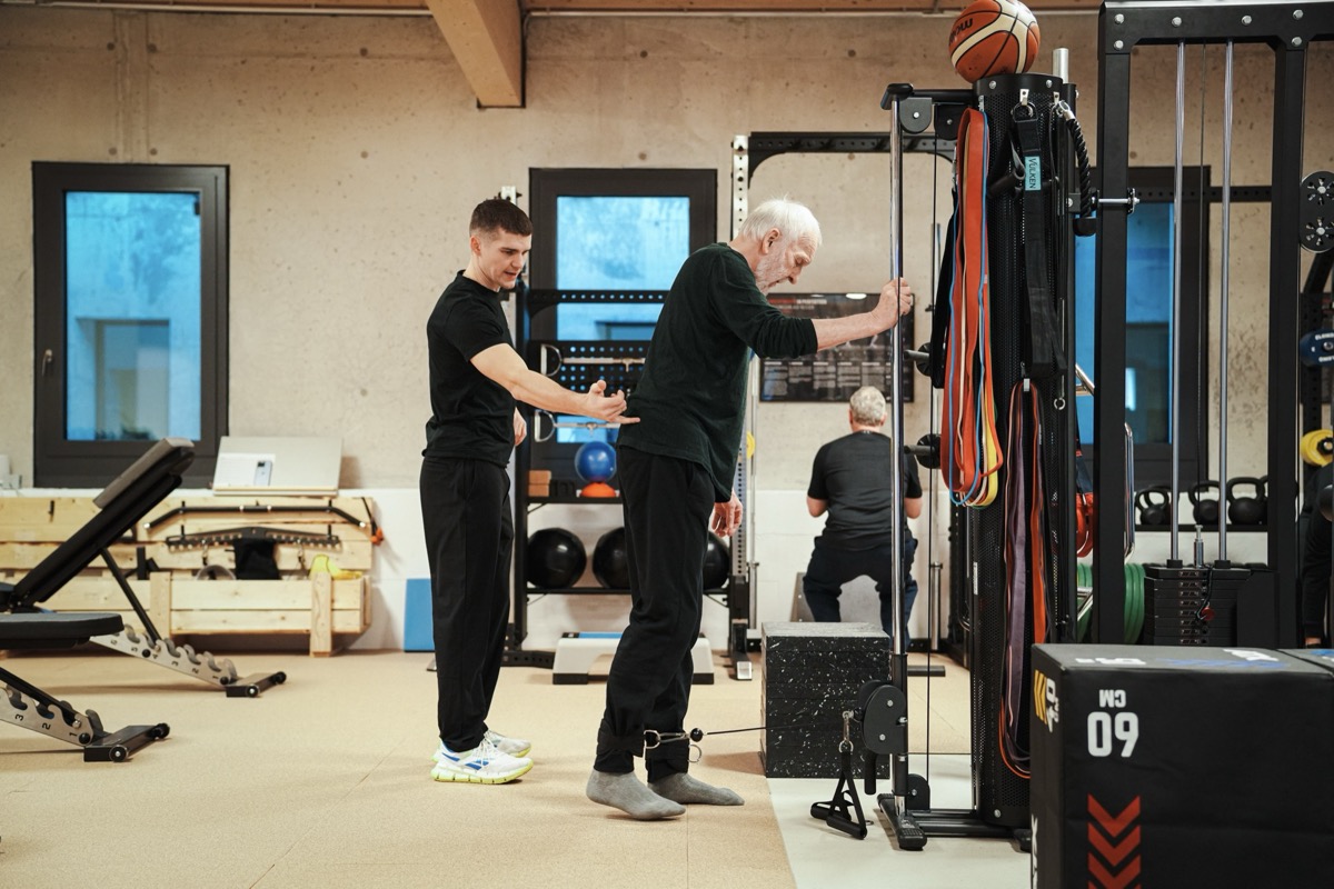 BRIKS Studio – Trainer begleitet Kunden am Kabelzug